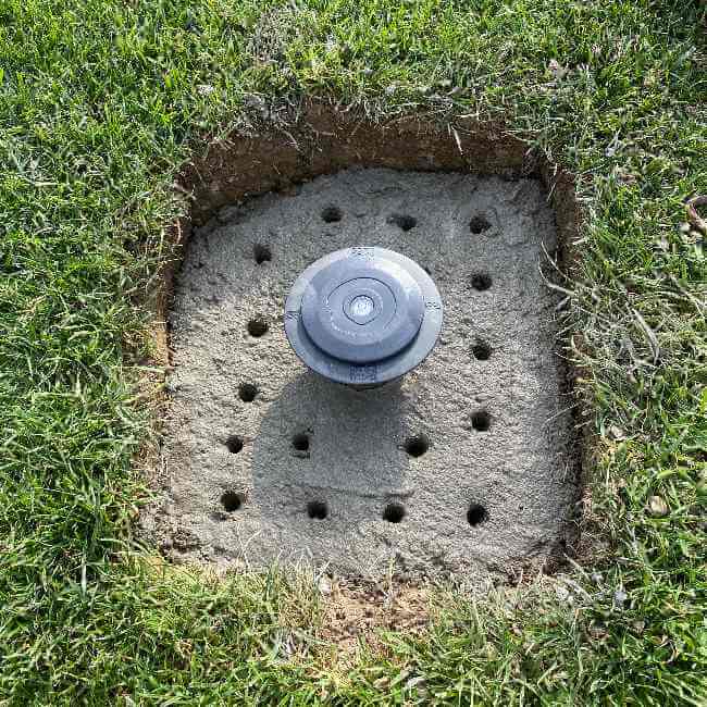 Installation au sol avec du béton de la base d'ancrage pour parasol