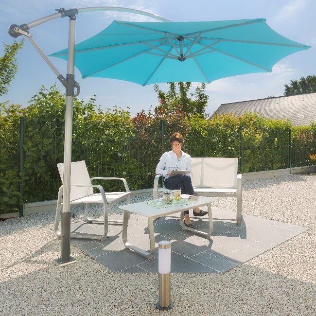 Femme profitant de son jardin sous son parasol déporté