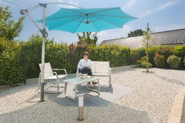 Femme profitant de son jardin sous son parasol déporté